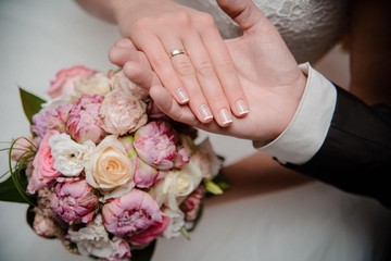 Obraz na płótnie Canvas The bride and groom hold hands. Bridal bouquet