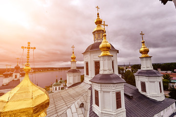 Fototapeta na wymiar Eastern orthodox crosses on gold domes, cupolas, against blue sky with clouds