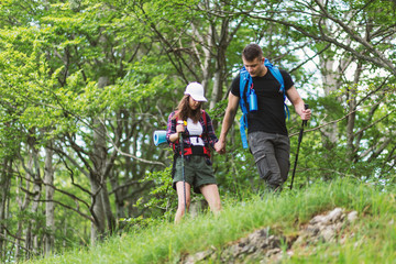 Obraz premium Beautiful young couple hiking together in the woods
