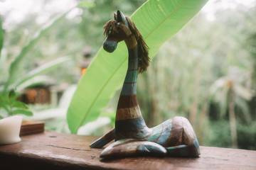 color graceful horse made of wood with tropical forest on background in Bali