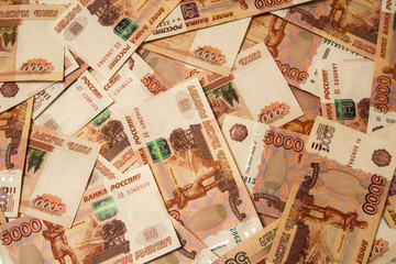 Banknotes of Russian currency face value of 5,000 rubles scattered on the table are a sign of...