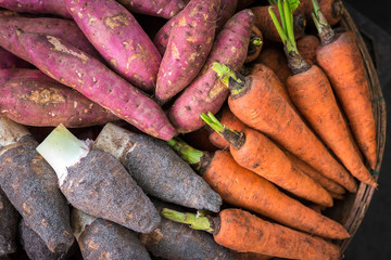 Colorful roots (sweet potatoes, carrot and taro) at Cho Con market, Danang (Vietnam) in the mid of...
