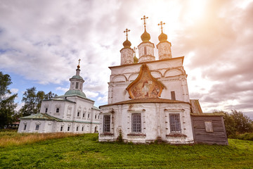 Old orthodox church at village. Summer view with floral meadow. Sun flare