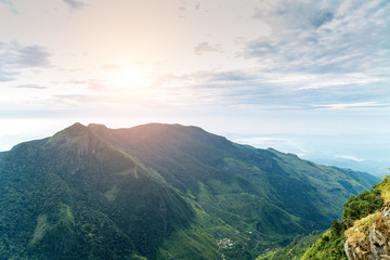 Mountains in summer time sunrise cloud forest Worlds End in Horton Plains National Park Sri Lanka.