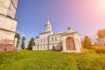 Naklejka premium Old orthodox church at village. Summer view with floral meadow. Sun flare