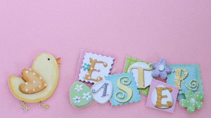 Baby chick next to Easter banner on pink background