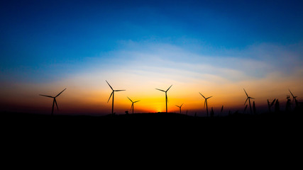 Naklejka premium Landscape photo Wind turbines silhouette at sunset 