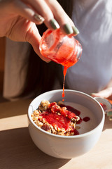 large and deep white plate filled with a dry blend of oat flakes with nuts, seeds and dried fruits. Tasty morning breakfast - granola