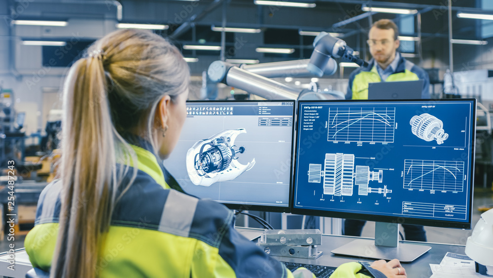 Aufkleber At the Factory: Female Mechanical Engineer Designs 3D Engine on Her Personal Computer. In the Background Male Automation Engineer who Uses Laptop for Programming Robotic Arm.