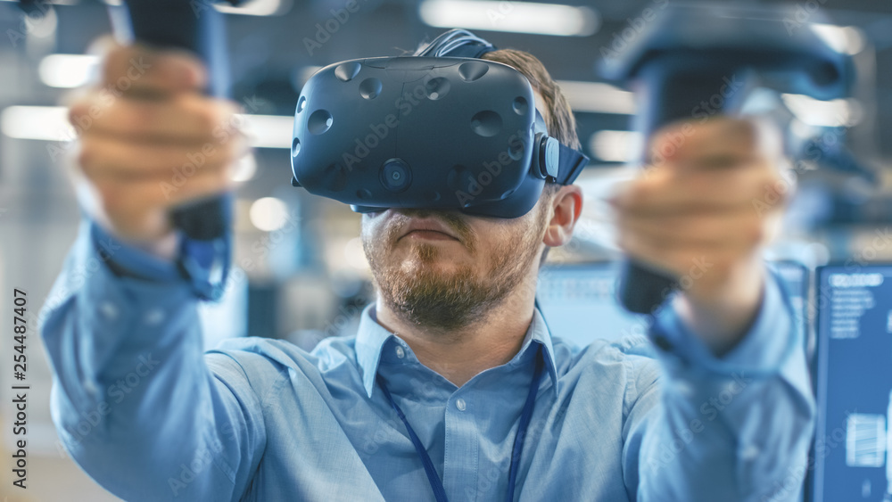 Poster portrait shot of the industrial engineer wearing virtual reality headset and using controllers, read