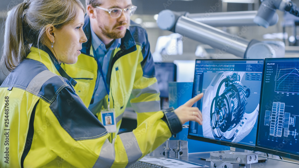 Aufkleber at the factory: male mechanical engineer and female chief engineer work together on the personal com