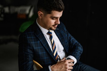 A handsome man in a blue suit in a cage posing in the Studio. Business portrait.