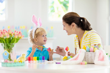 Fototapeta na wymiar Mother and kids, family coloring Easter eggs.