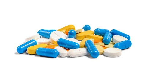 A pile of different multicolored pills, tablets and capsules isolated on white background. Pharmacy theme. Selective focus.