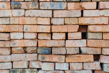 A stack of red old bricks texture. Clay brick used for construction.