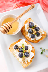 Toast with fresh berries blueberry Ricotta cheese, thyme, honey and hazelnuts, served