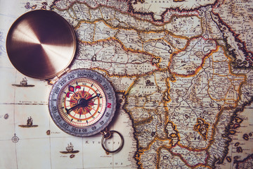 Compass lies on an old map. Orientation on the ground by compass.