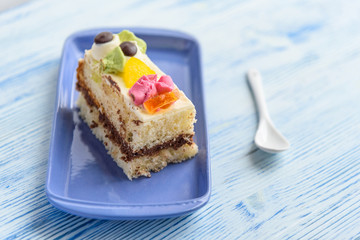 A slice of sponge cake on a rectangular plate.