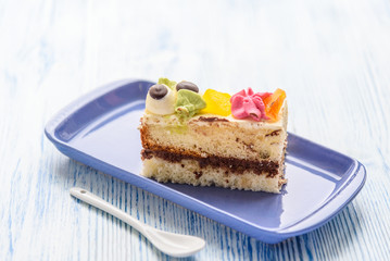 A slice of sponge cake on a rectangular plate.