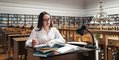 High school or college student studying and reading in library