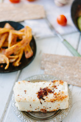 Big piece of tofu - vegan cheese, roasted. With vegetables and other food.