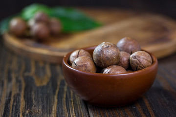 Macadamia nuts in a brown ceramic bowl.