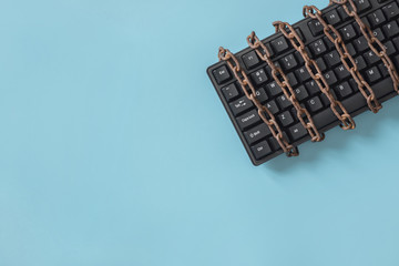 Black keyboard with a coiled chain. Concept for the topic of censorship or freedom of the press. - obrazy, fototapety, plakaty