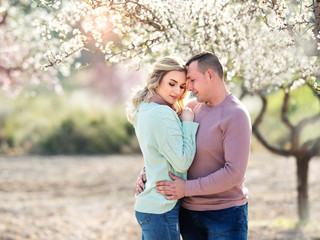 Fototapeta premium Beautiful couple in the flowering gardens in the spring