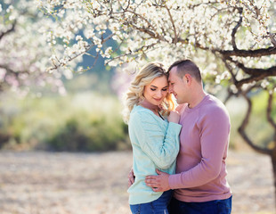 Fototapeta premium Beautiful couple in the flowering gardens in the spring