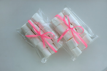 White chewing Marshmallows in a bag on white background with copyspace