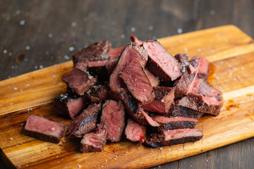Slices of steak on a cutting board ready to be served.​