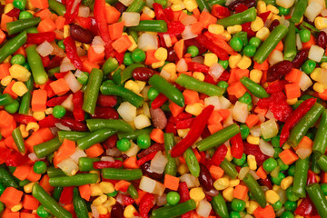 Sliced vegetables, corn, beans, peas, carrots, sweet peppers background.