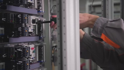 a professional assembles an electrical circuit and twists a screwdriver