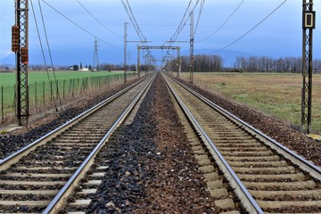 railway in the field two strips of rail and wires above them