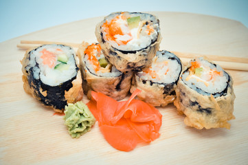 hot homemade roll tempura shrimp and avocado lying next to the ginger, the concept of home Asian-inspired dinner.