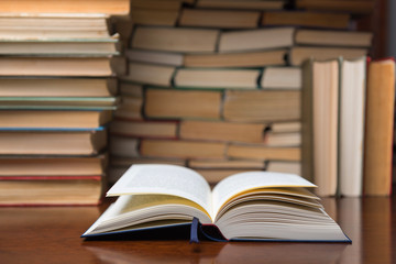 open book on the table, on the background of many books