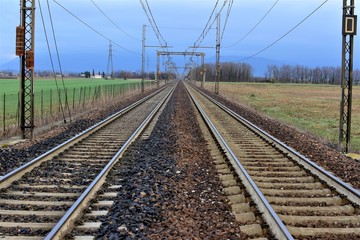 Fototapeta premium railway in the field two strips of rail and wires above them