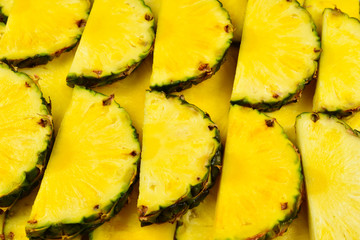 Pineapple juicy yellow slices background. Top view.