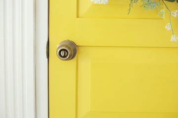 Beautifully decorated farmhouse look. Bright yellow door, a spring greenery wreath of flowers, a...