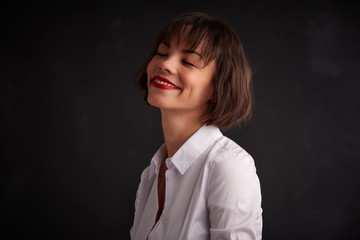 Portrait of beautiful young woman with closed eyes posing at dark background