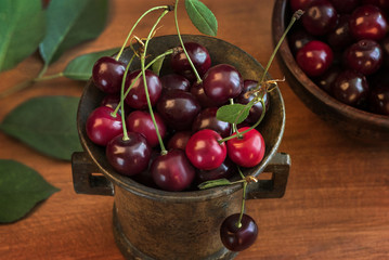 ripe cherry in a bronze vintage vase on the table