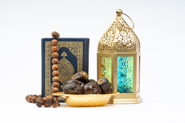 Lantern, Dates, Koran and Rosary on white background with selective focus and crop fragment. Ramadan, Religion and Copy space concept