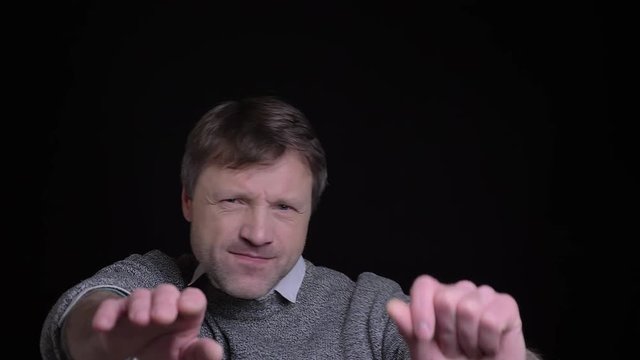 Closeup portrait of adult caucasian man dacing and having fun in front of the camera with background isolated on black