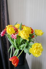 beautiful bouquet of spring flowers yellow and red tulips in a black vase