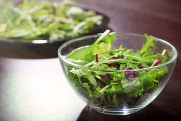 A mixed raw salad from the leaves of arugula, spinach and romaine, a close-up.