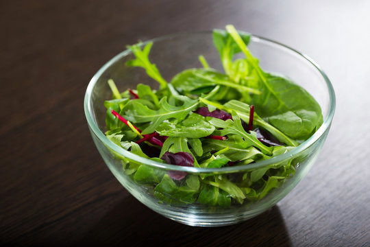 A fresh mixed salad on a wooden table. A notion of a useful and healthy meals.