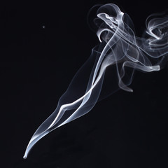 White and blue smoke on a black background. Sharp curls and smoke and out of focus.