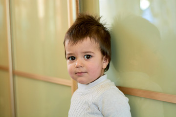 Closeup indoor portrait of a baby boy with naughty hair. The various emotions of a child are...