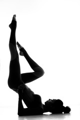 Fototapeta premium Stunning shape. Silhouette of a gymnast woman standing upside down showing off her perfectly shaped body