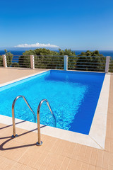 Blue swimming pool steps sky and sea